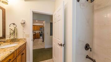 A bathroom with a sink, towel rack, and shower.