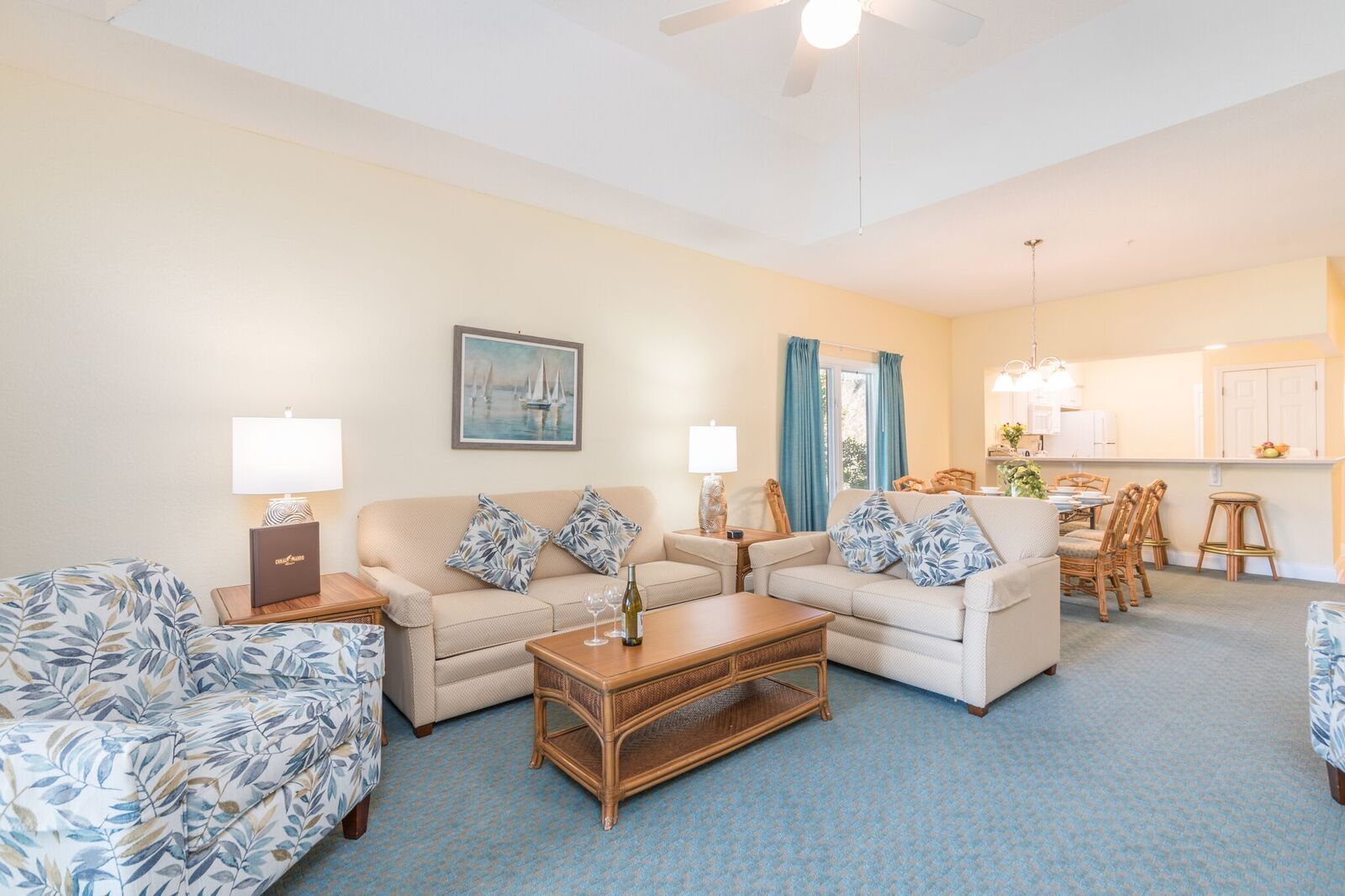 A living room with a sofa, two armchairs, a coffee table, and a dining area with a table and chairs.