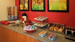 Een ontbijtbuffet met diverse soorten eten, zoals fruit, gebak en drankjes.