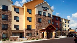 Een meerlaags hotel met een stenen gevel, een opvallend 'TownePlace Suites by Marriott' bord en een overdekte ingang.