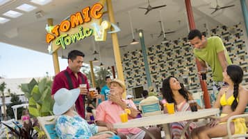 A lively outdoor seating area with a neon sign reading "ATOMIC Tonic."