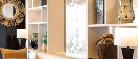 A modern living room with a sofa, decorative vases, and a mirror on the wall.