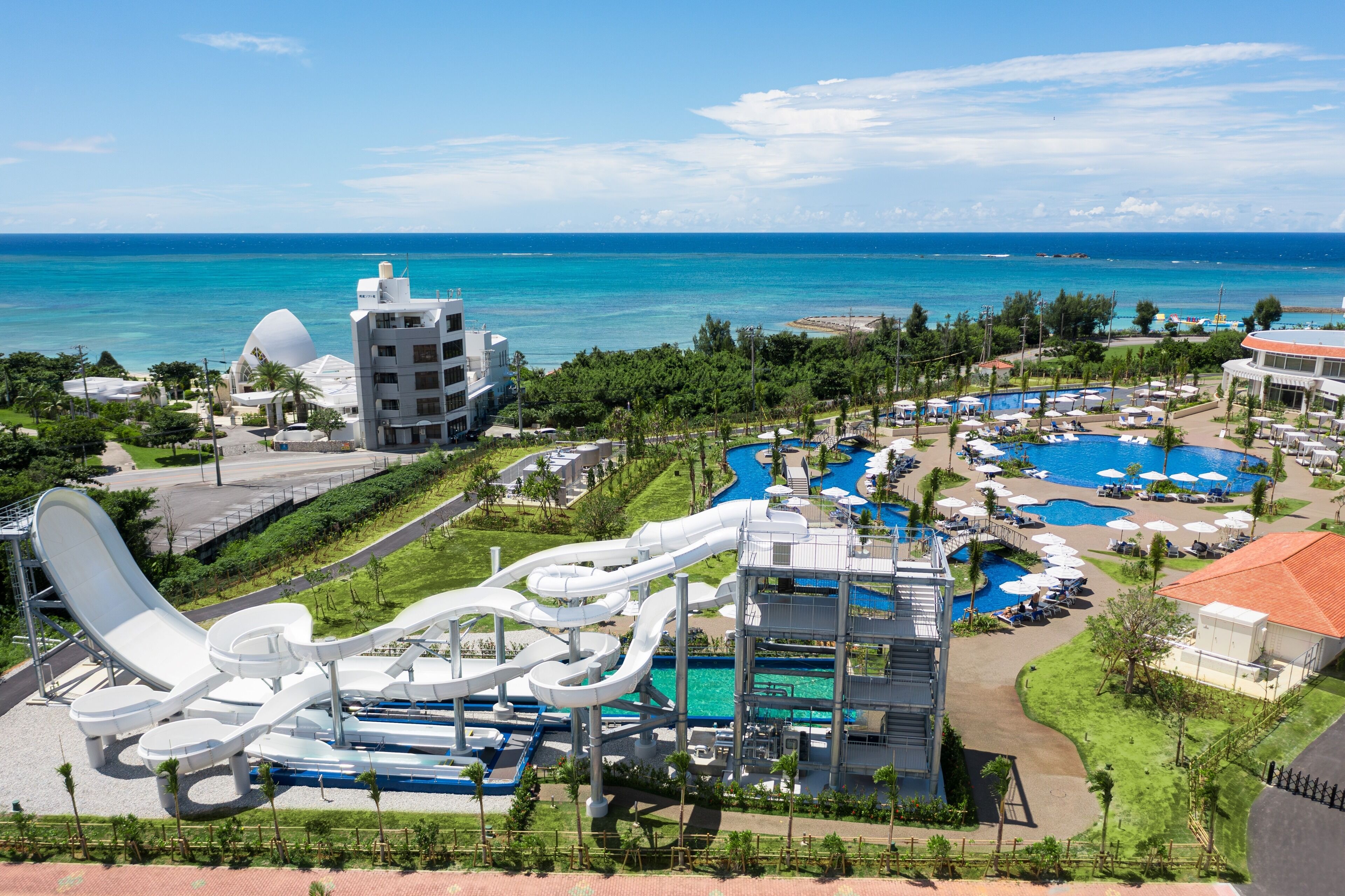 A resort with a water park, multiple swimming pools, and a view of the ocean.