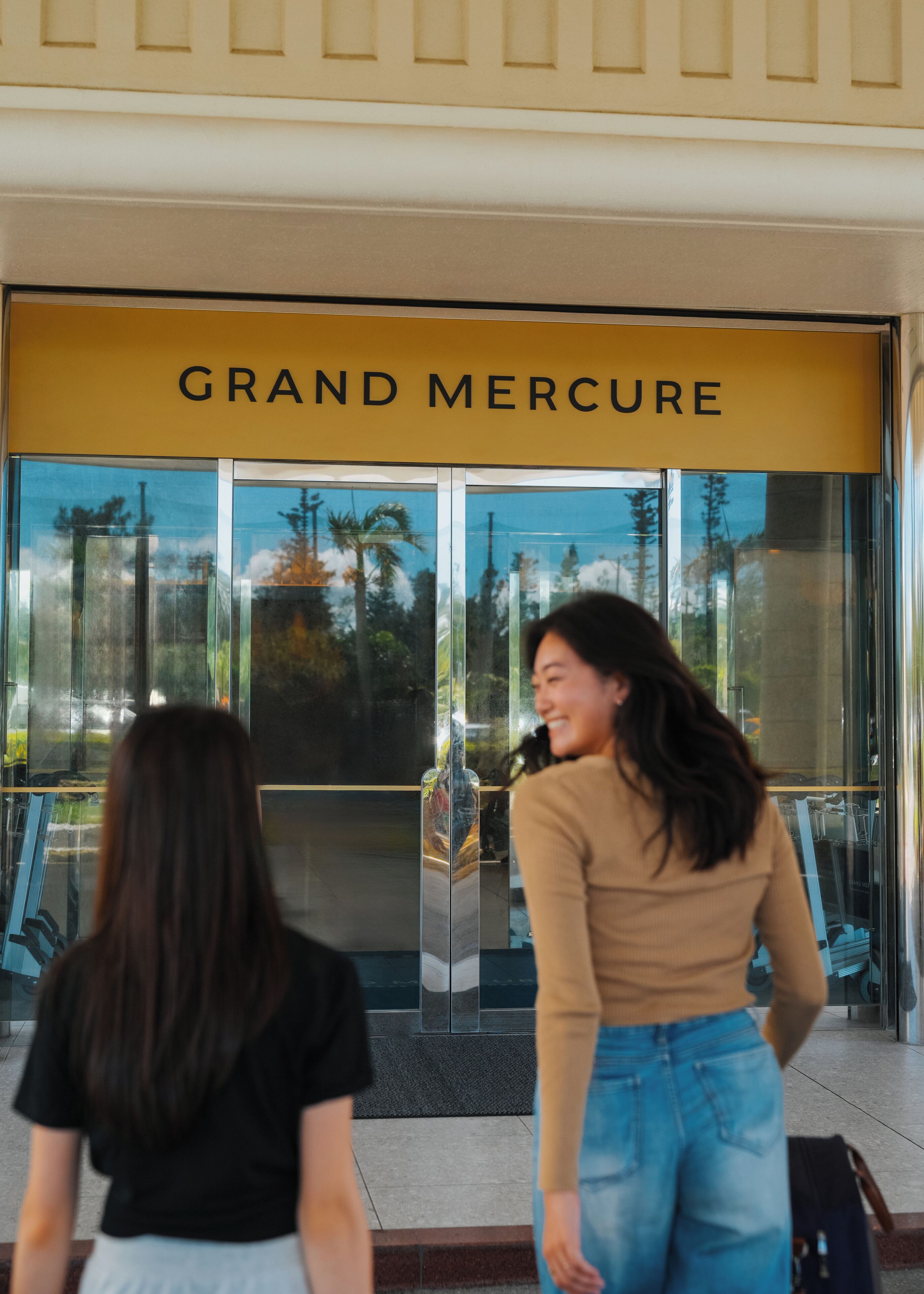 A entrada do Grand Mercure, com vista clara para as portas de vidro e a fachada do edifício.