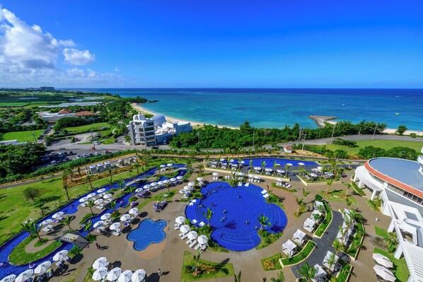 A resort with a large central pool, multiple smaller pools, and a beach area.