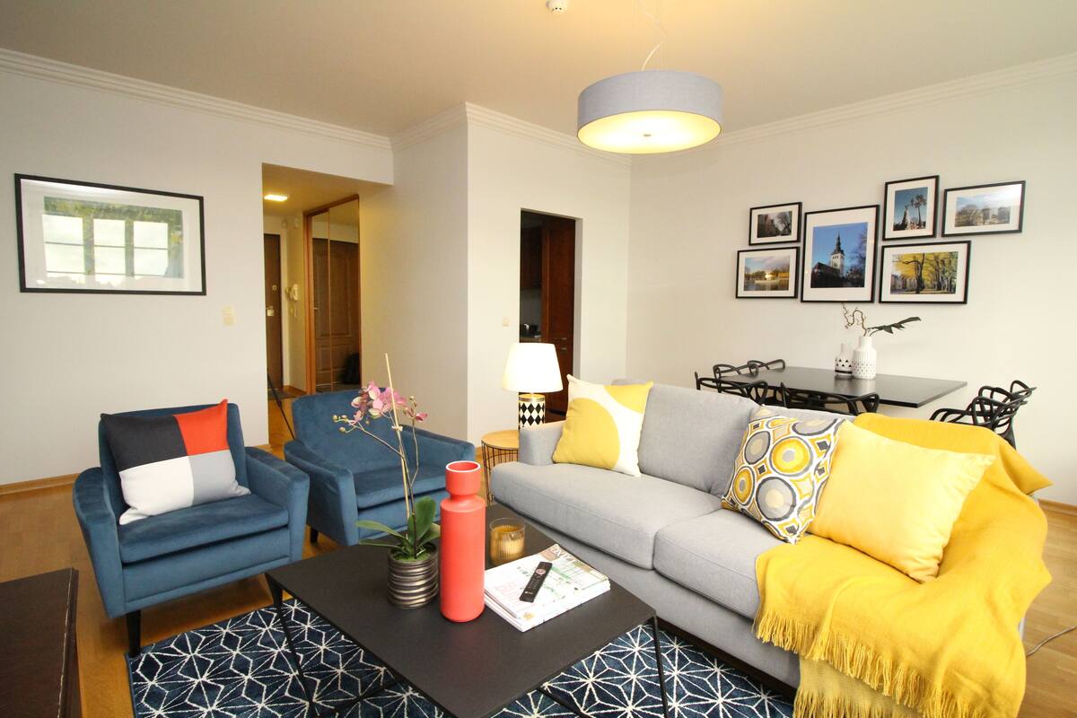 Un salon comprenant un canapé, des fauteuils, une table basse et un coin repas avec une table et des chaises.