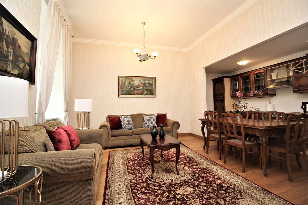 Un salon comprenant un canapé, une table basse et un coin repas avec des chaises et une table.