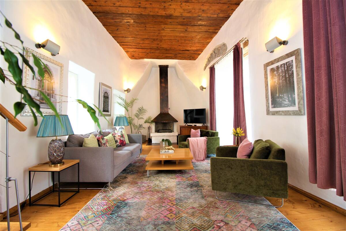 Un salon chaleureux avec une cheminée, un téléviseur et des fauteuils confortables.