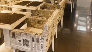 Ein Restaurantinneres mit verschiedenen Sitzbereichen, darunter Boxsitzgelegenheiten und Tische, sowie einer Wand mit gerahmten Bildern und einer Uhr.