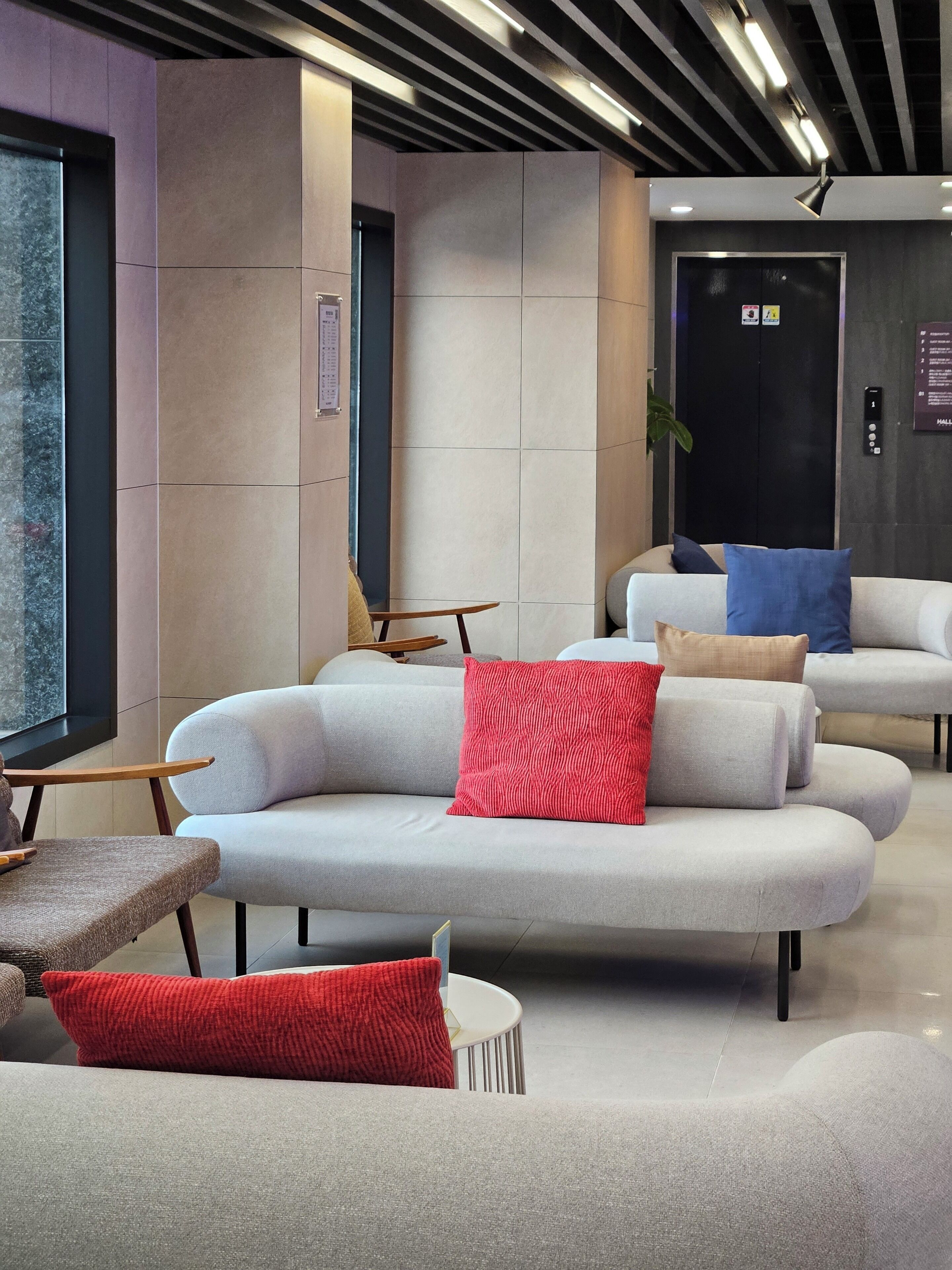 A modern lobby with a curved sofa, a small table, and a reception desk.