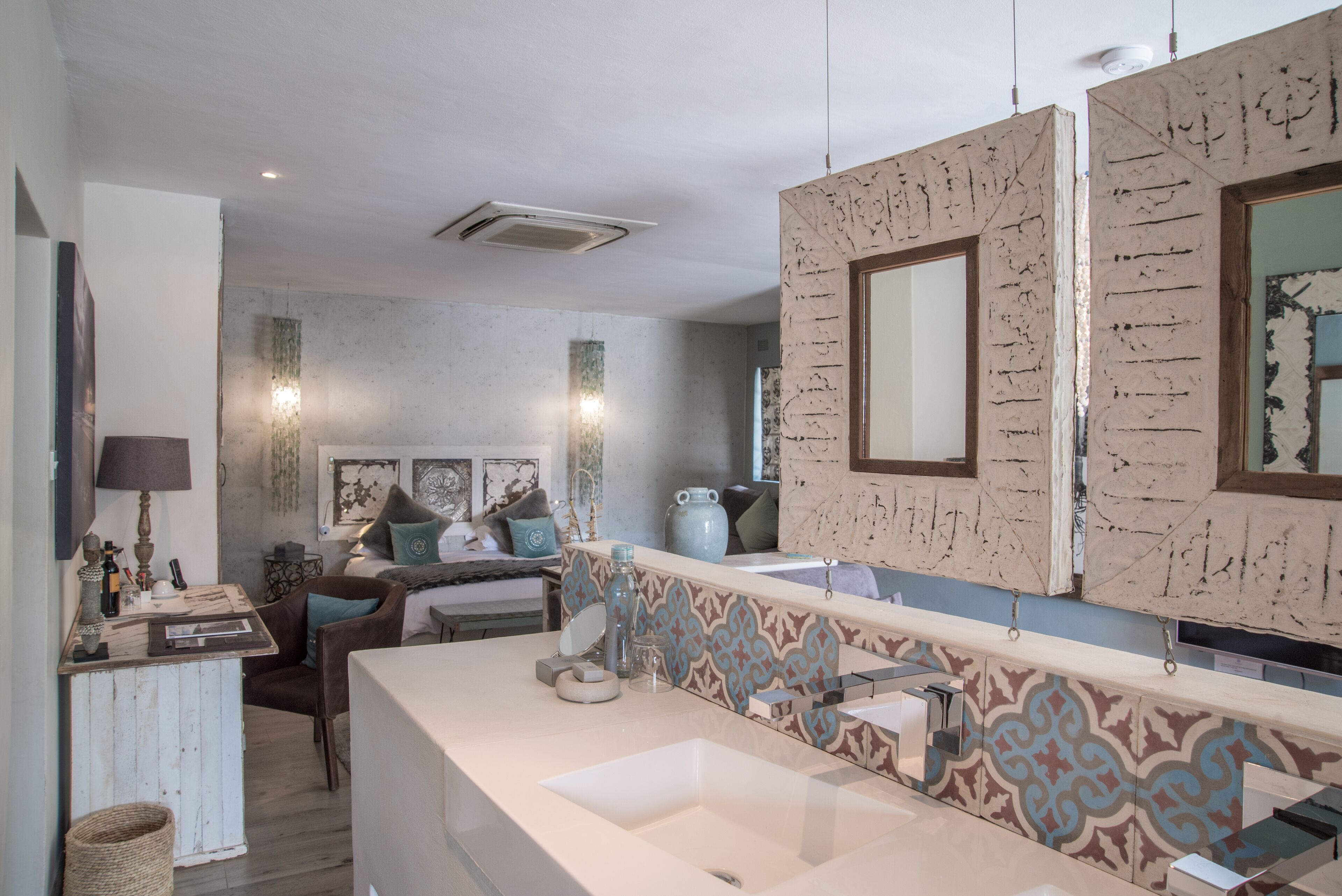A modern bathroom with a large mirror, a bathtub, and a vanity with a sink.