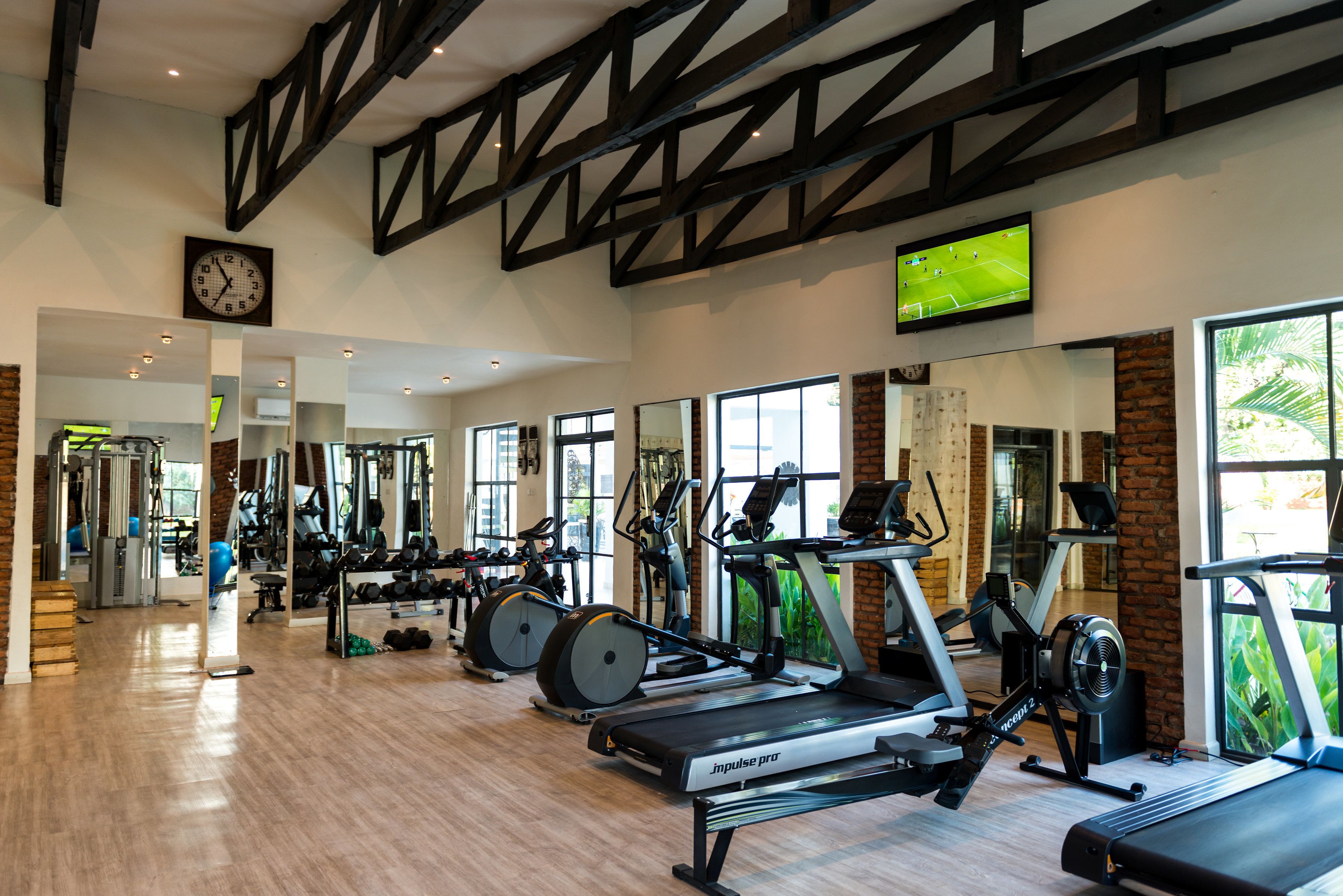 Une salle de sport équipée de tapis de course, de vélos elliptiques et d'appareils de musculation.