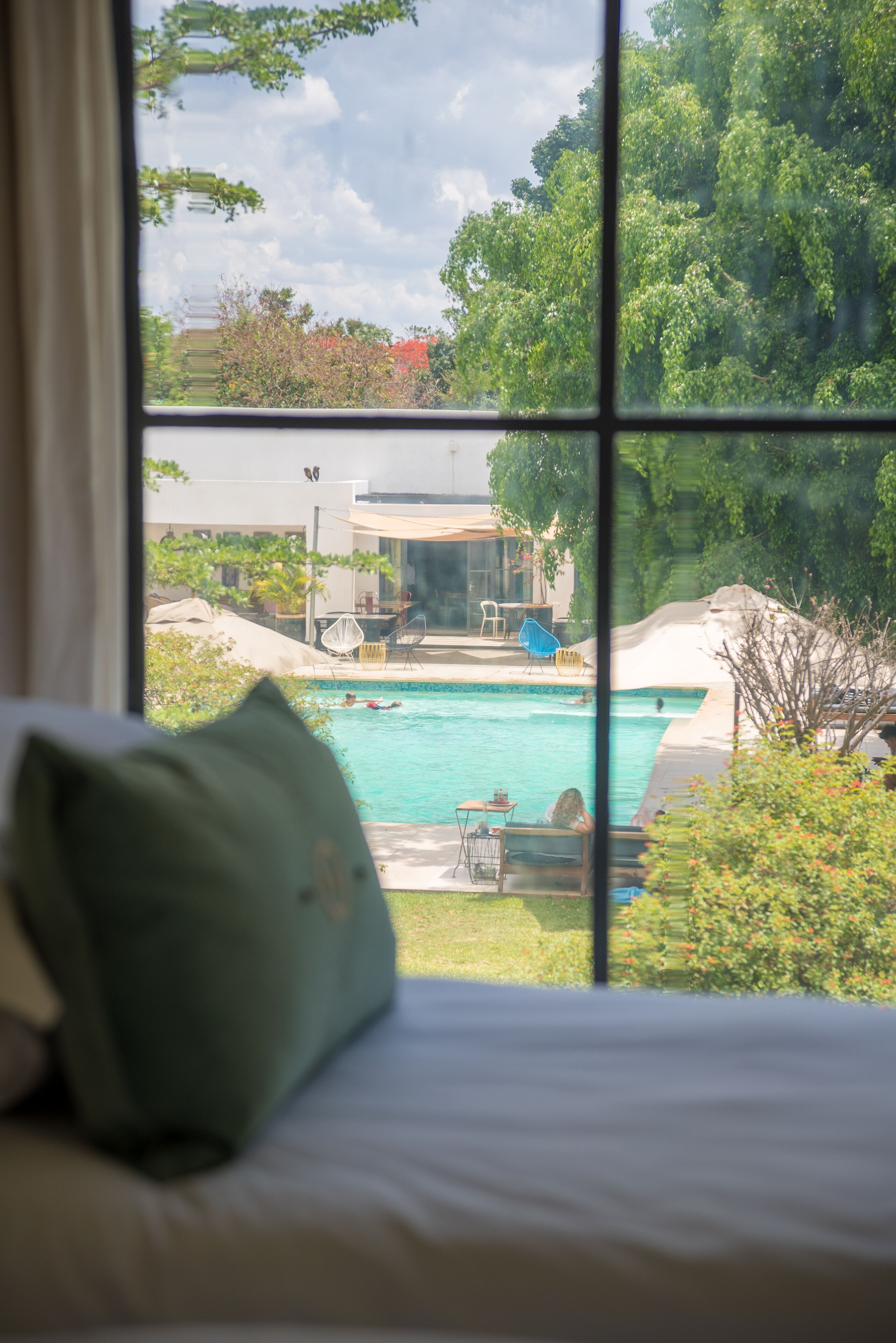 Quarto com vista para uma piscina e mobiliário de exterior.