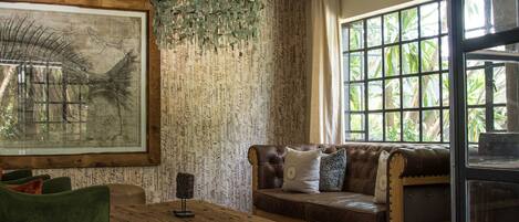 Una sala de estar acogedora con una mesa de centro de madera, un sofá verde y un sofá de cuero marrón.