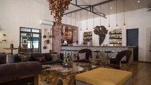 Un área de bar moderna con pared de ladrillo, luces colgantes y una variedad de botellas.