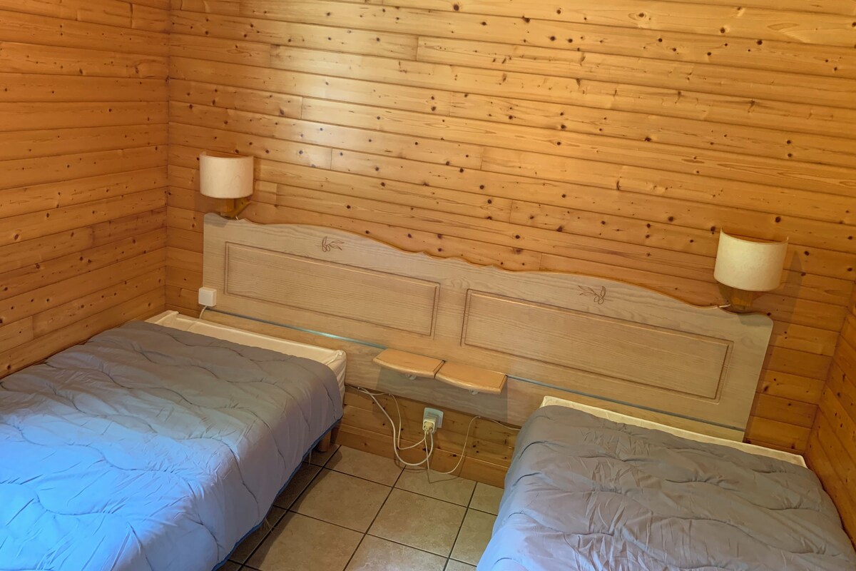Ein kleiner, gemütlicher Raum mit Holzwänden und einer schlichten Bettausstattung.