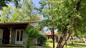 A rustic cabin with a porch and a small garden area.