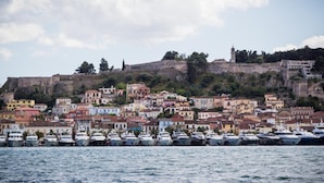 A coastal town with a historic fortification on a hill, colorful buildings, and a marina with boats. - Acronafplia Pension A (Nafplio)