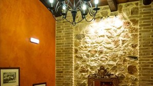A staircase with wooden railings, a stone wall, and a chandelier. - Acronafplia Pension A (Nafplio)