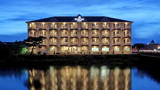 Ein mehrstöckiges Hotel mit einem Reflektorpool davor, mit Balkonen und einem gut sichtbaren Schild obenauf.