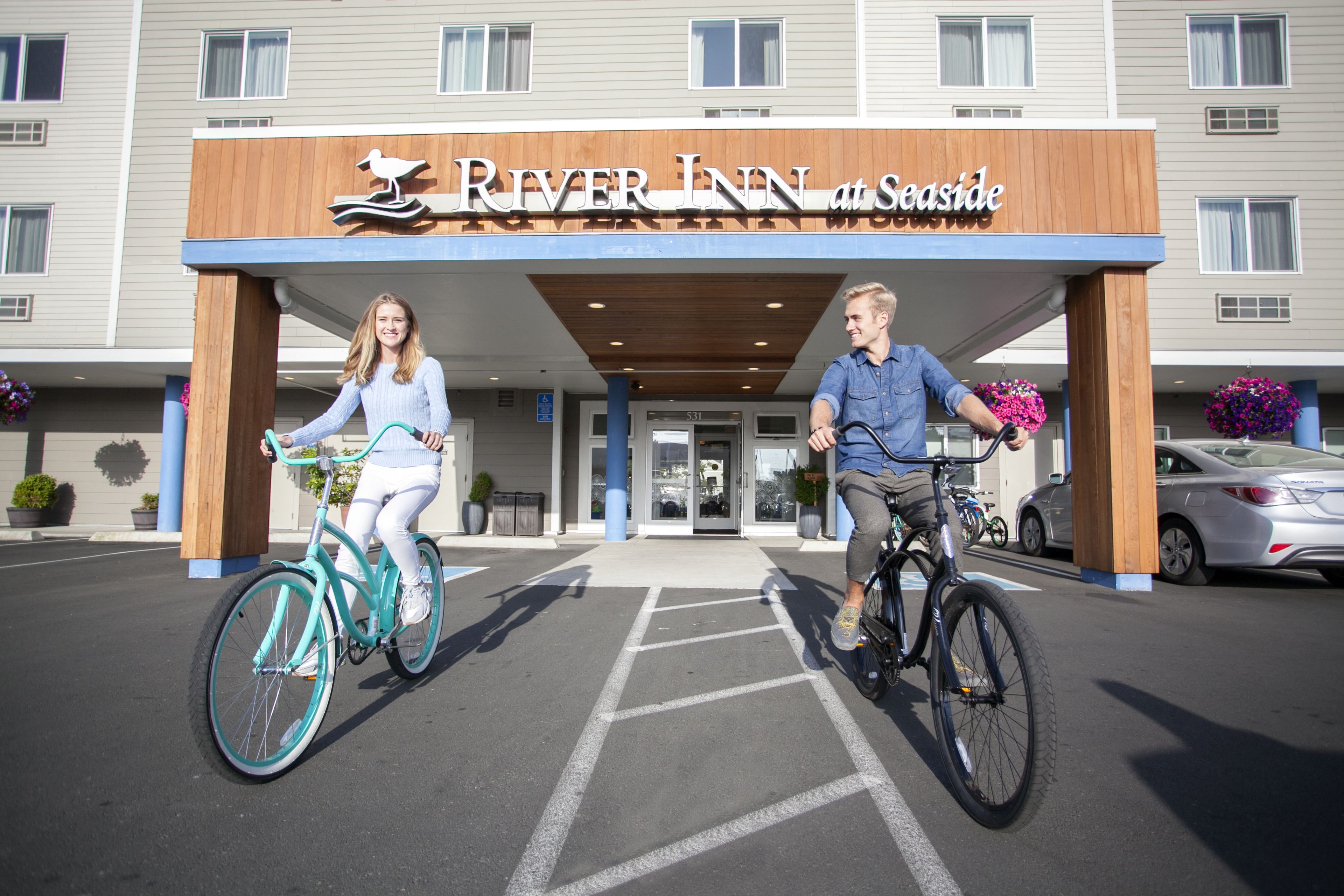 A hotel entrance with a sign reading "River Inn at Seaside."