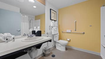 A modern bathroom with a sink, mirror, toilet, and shower.