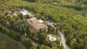 An aerial view of a property with a large building, a swimming pool, and a circular fountain. There are trees and a vineyard in the surrounding area. - Locanda Antiche Macine (Santarcangelo di Romagna)