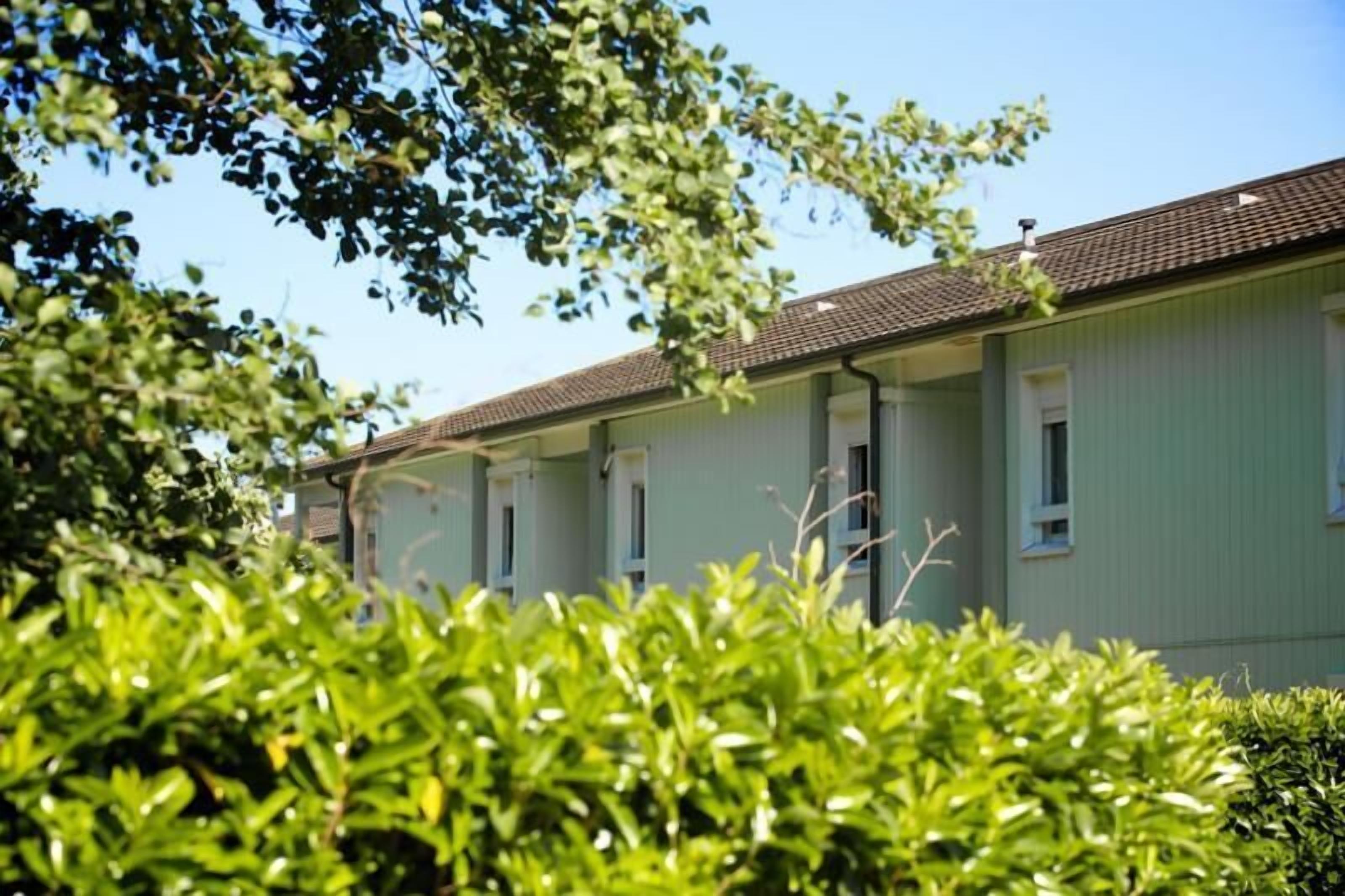 A row of single-story buildings with a uniform facade, likely part of a residential or institutional complex.
