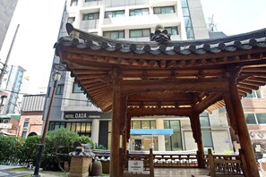 A traditional wooden pavilion with intricate roof design, located in an urban setting with modern buildings in the background. - Hotel Dada Gyeongbokgung (Seoul)