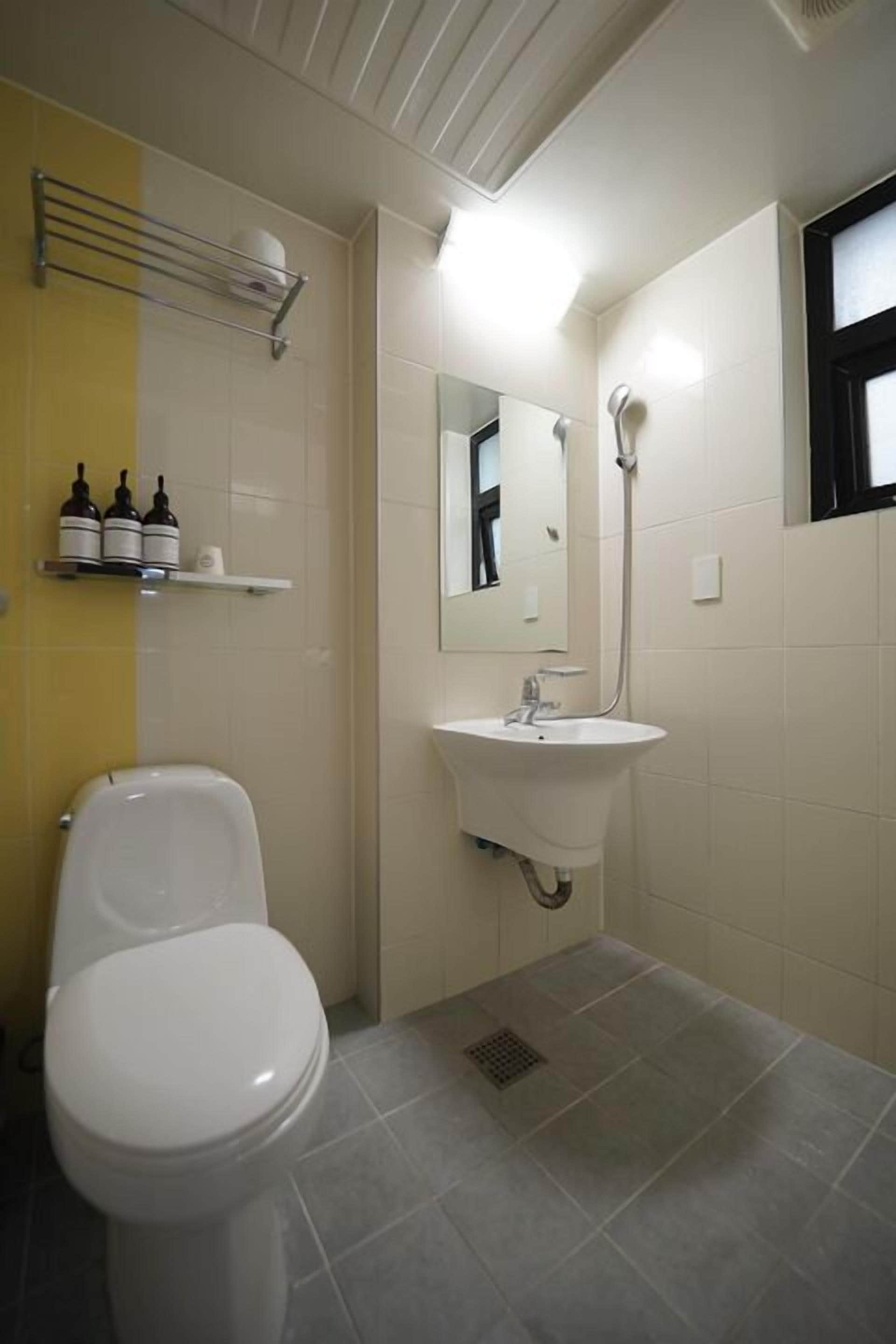 Ein Badezimmer mit Toilette, Waschbecken und Spiegel.