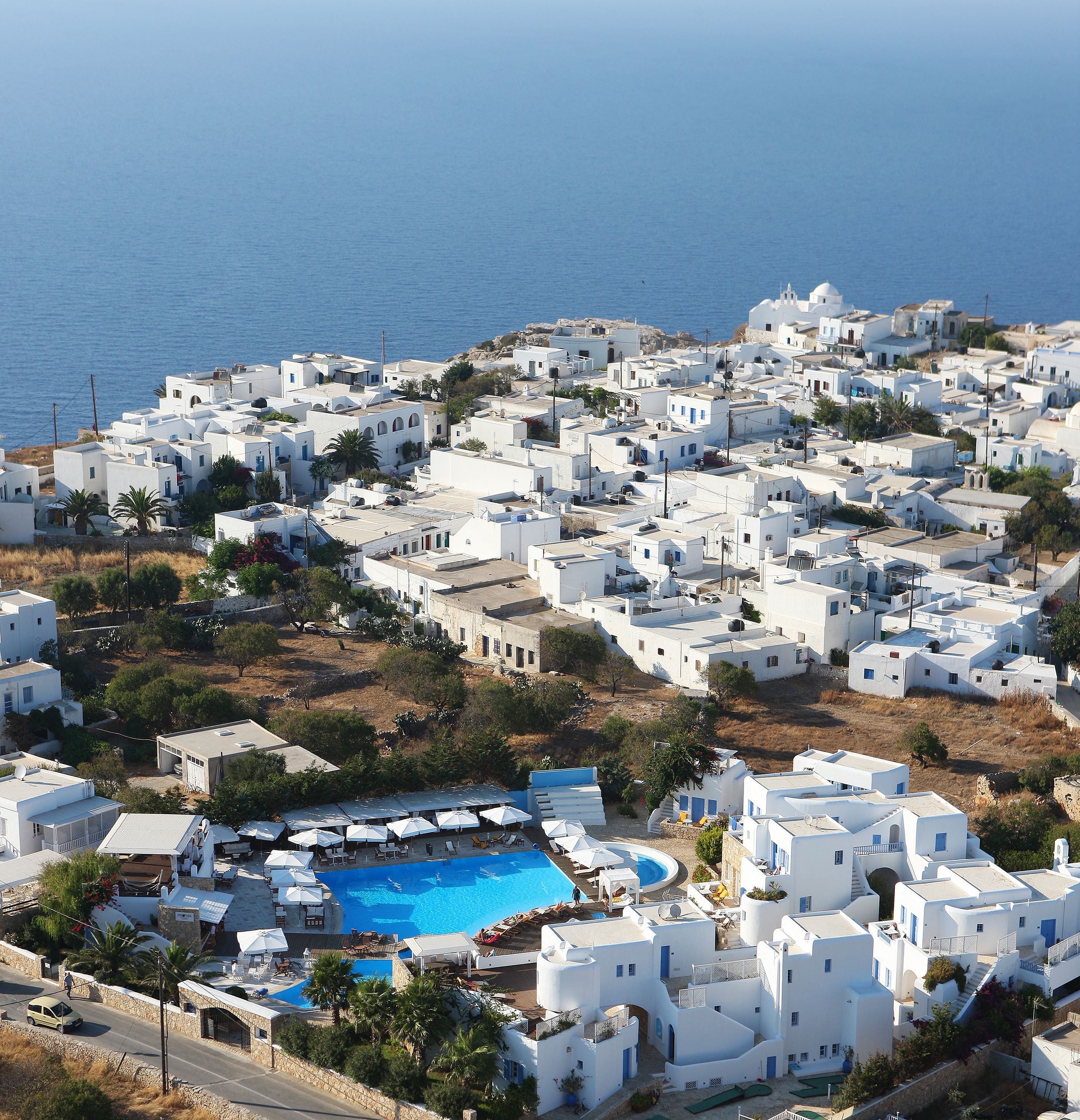Un village côtier aux bâtiments blancs, doté d’une piscine et offrant une vue sur la mer.