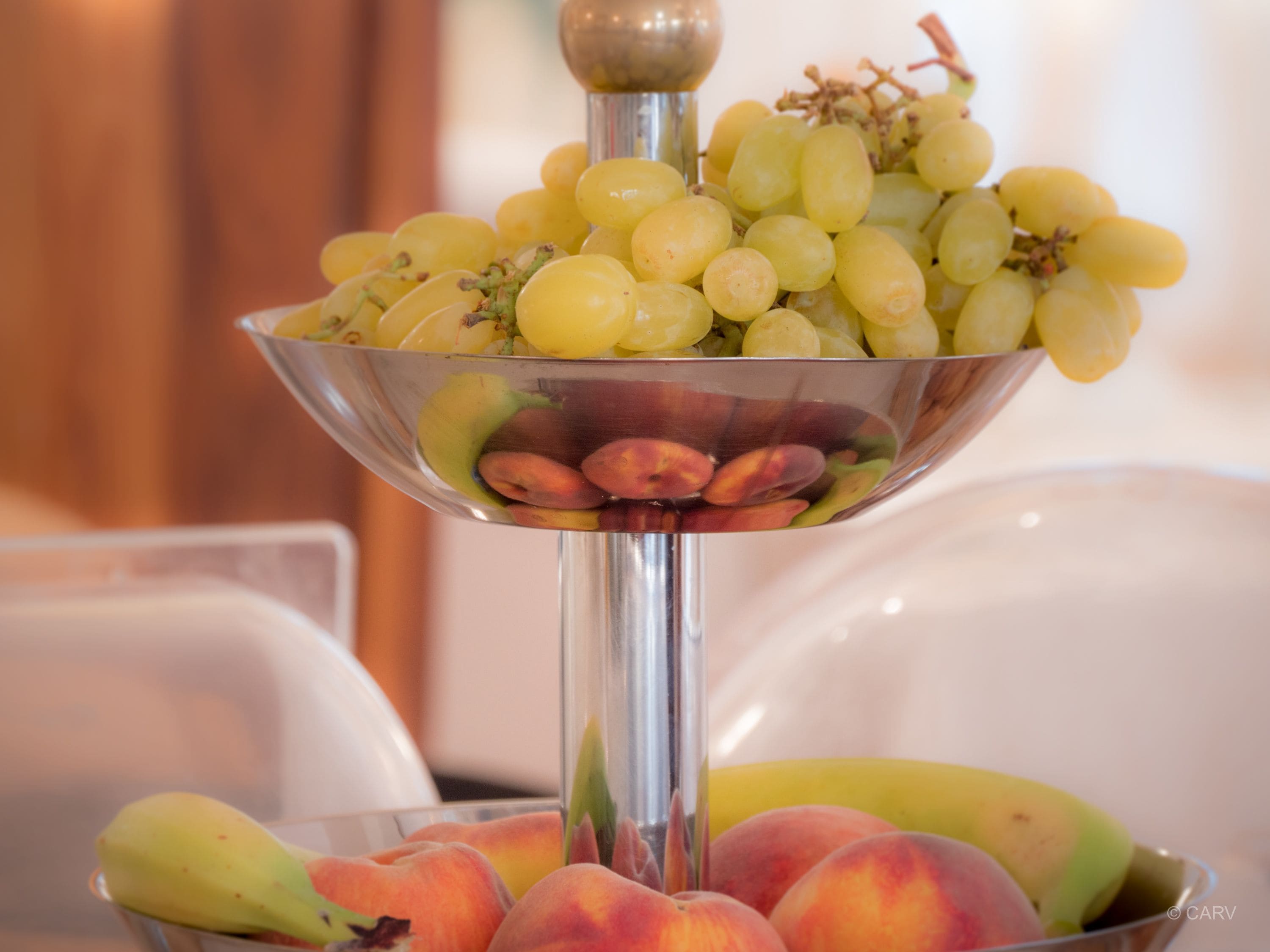 A fruit stand with grapes and peaches.