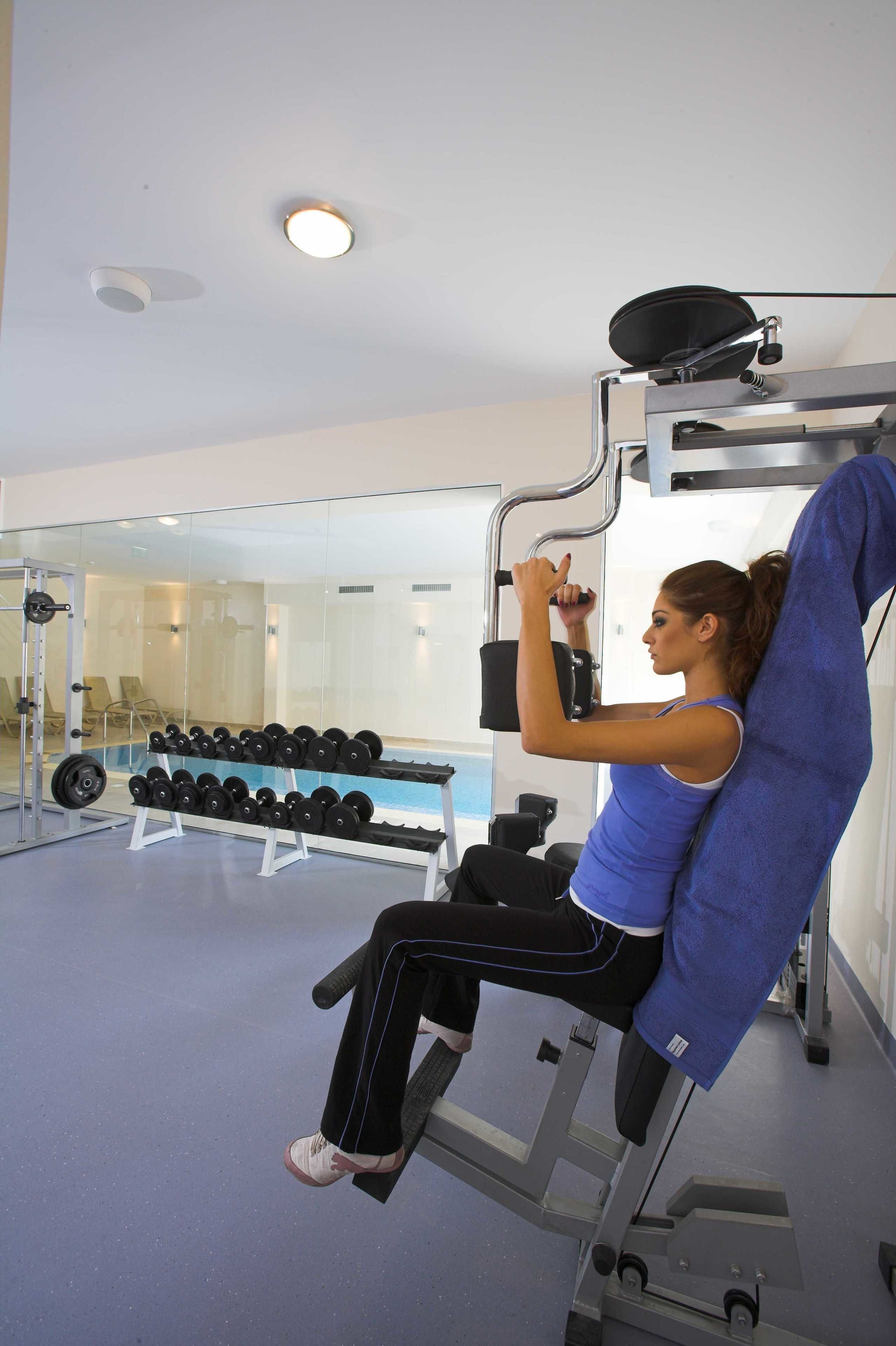 Une salle de sport équipée de matériel d’exercice, d’un miroir et d’un porte-haltères.