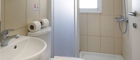 A bathroom with a sink, toilet, and shower.