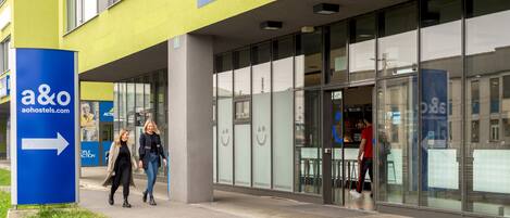 A building entrance with a sign for 'EINGANG/ENTRANCE' and a directional arrow sign for 'a&o'.