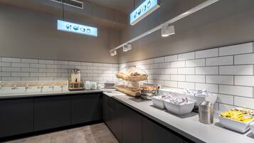 Une cuisine moderne avec un espace buffet, comprenant divers récipients pour les aliments et une machine à café.