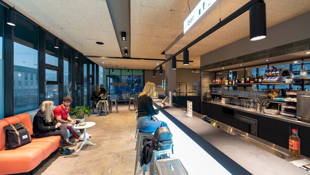Una zona de bar moderna con asientos y una barra.