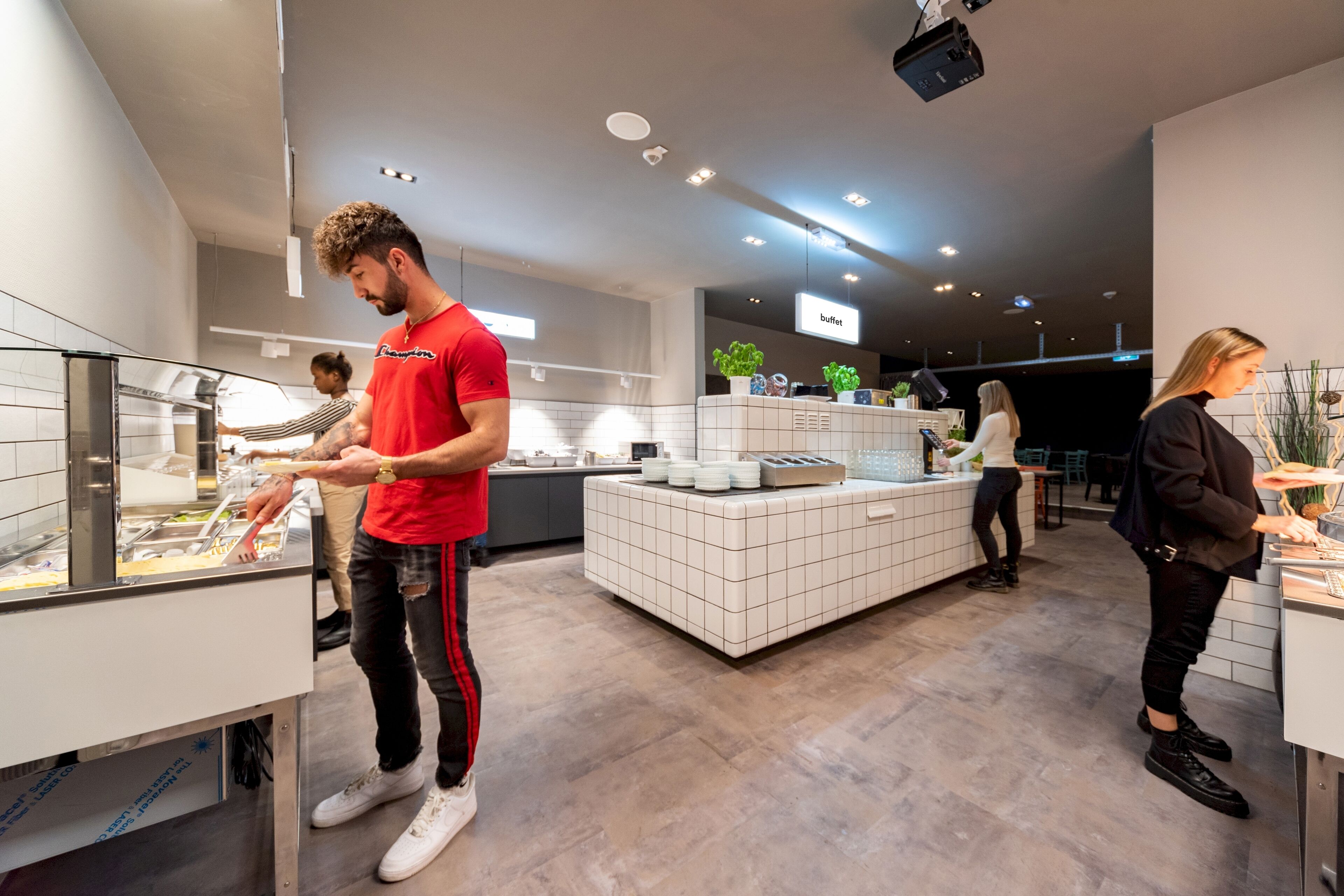 A modern kitchen area with a buffet setup, including a counter with food items and a display case.