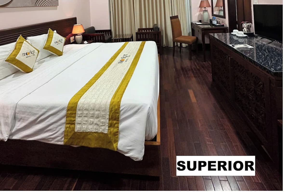 A hotel room with a bed, a desk, a chair, a television, and a mirror.