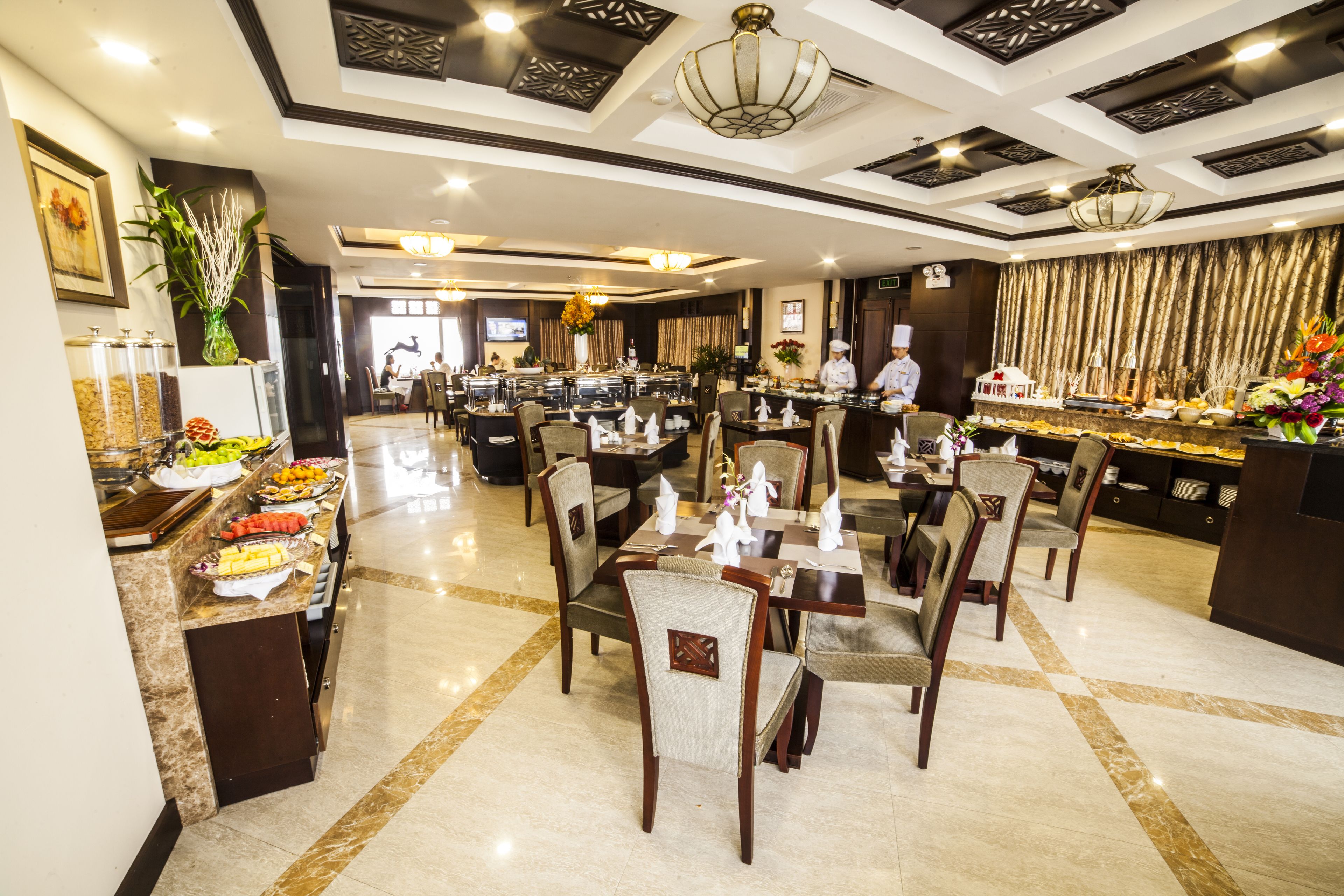 A spacious restaurant with marble flooring, multiple dining tables, and chairs.