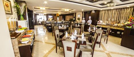 A spacious restaurant with marble flooring, multiple dining tables, and chairs.