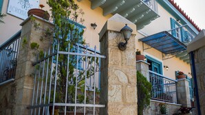 Un edificio con fachada de piedra, contraventanas azules y un balcón con barandilla.