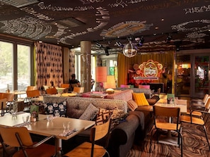 Un restaurant accueillant qui propose différents types de sièges, notamment des tables et un coin salon avec des canapés.