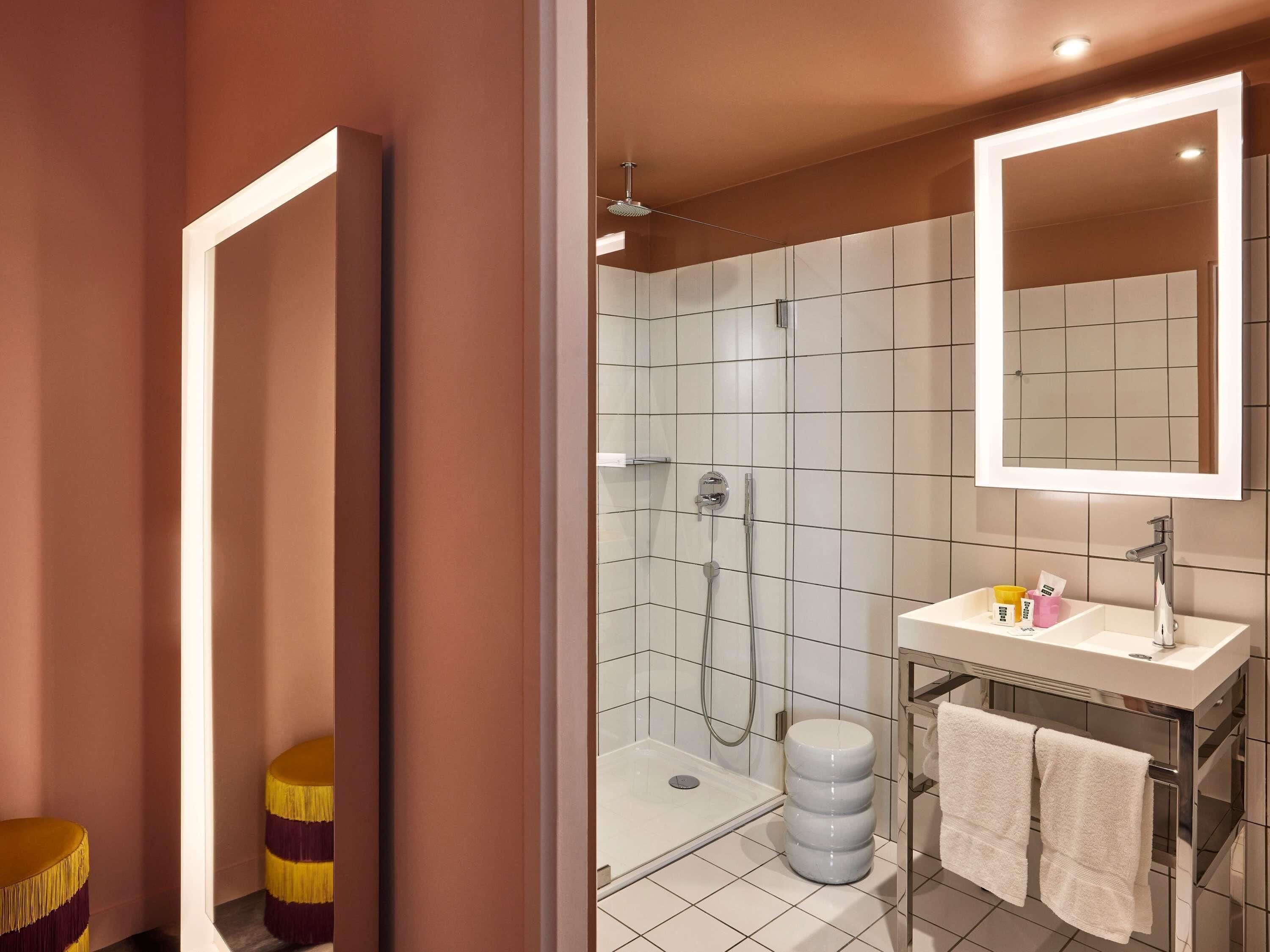 Et stilfuldt badeværelse med bruser, vaskebord med spejl og toilet.