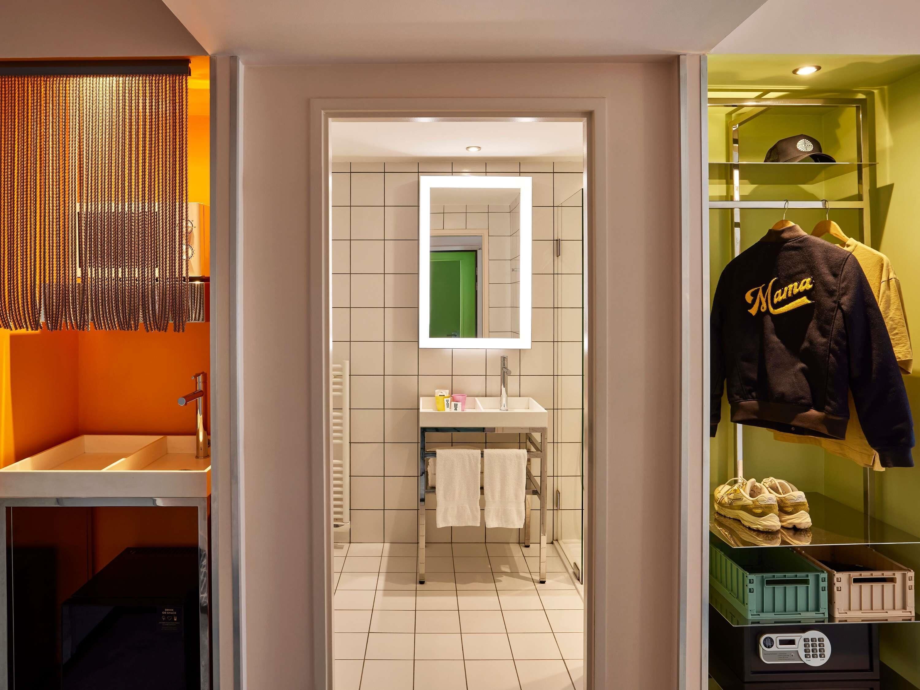 A modern bathroom with a mirror, sink, and towel rack.