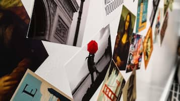 Una pared con varias fotografías y texto, que incluye un paraguas rojo y una persona.