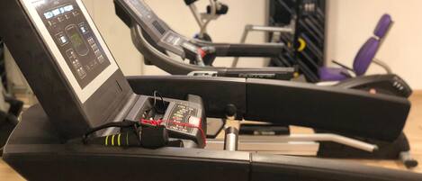 Cyclette, tapis roulant e vogatore in una palestra.