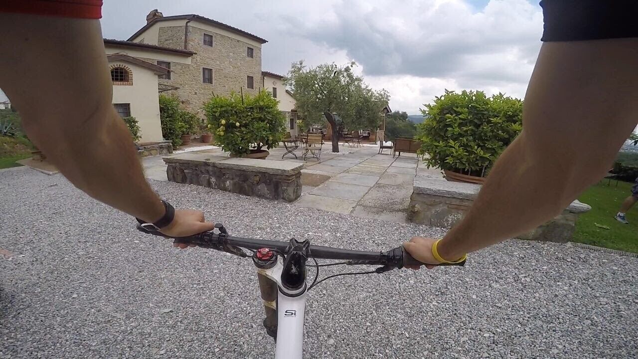A bicycle with a white frame and a logo, positioned on a gravel surface.