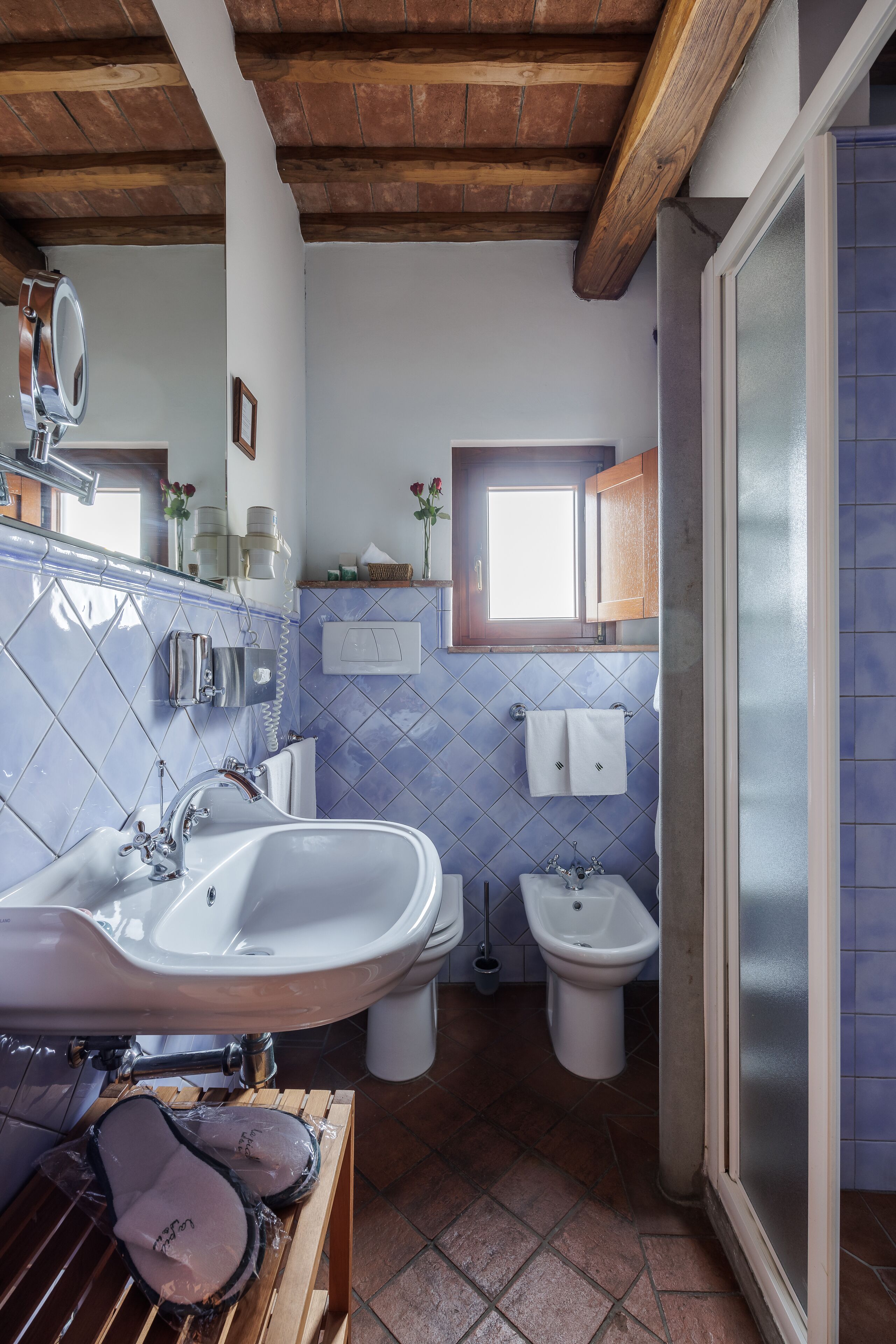 Un baño con un lavabo grande, un bidé y una ventana.