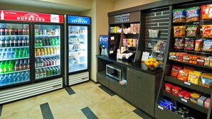Een automatenhoek met verschillende snacks en een drankkoeler.